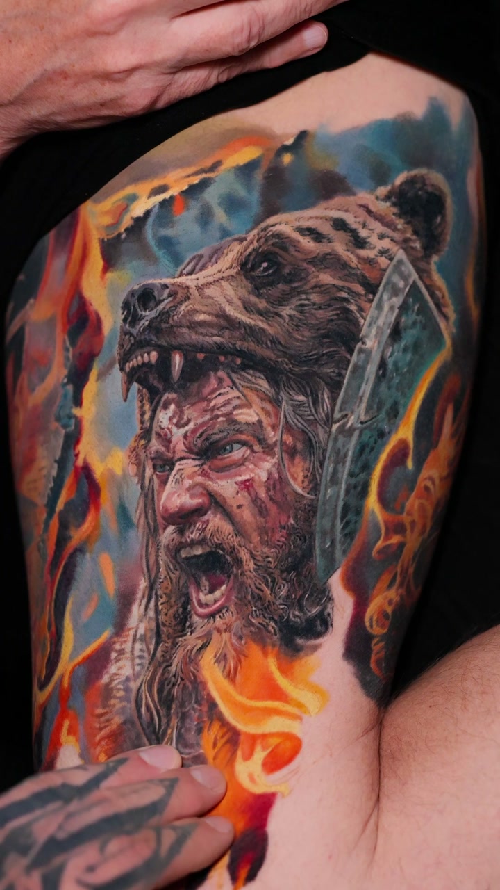 Healed color realism tattoo by Alex666cold — screaming Viking berserker in a bear-pelt hood with axe and fire, thigh