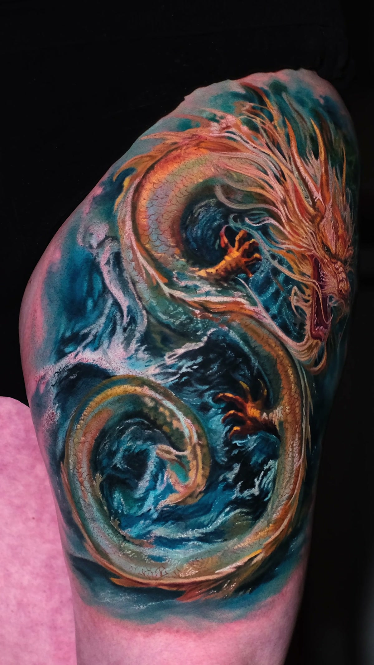 Weiteste Aufnahme: ganzer Oberschenkel mit dem chinesischen Drachen-Tattoo und Beinkontur. Cover-up auf dem Oberschenkel, Breslau.