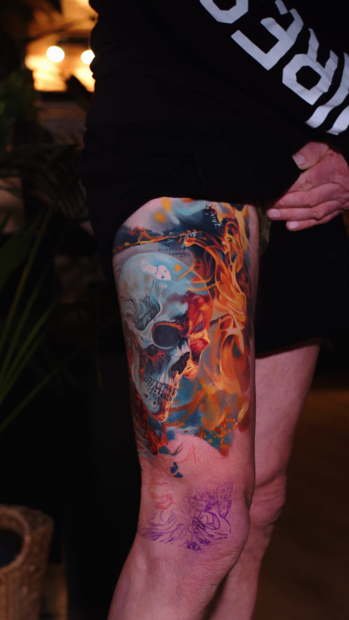 Frontansicht – realistisches Totenkopf-Tattoo in Flammen am Oberschenkel, in Arbeit, Color-Realism, Wrocław