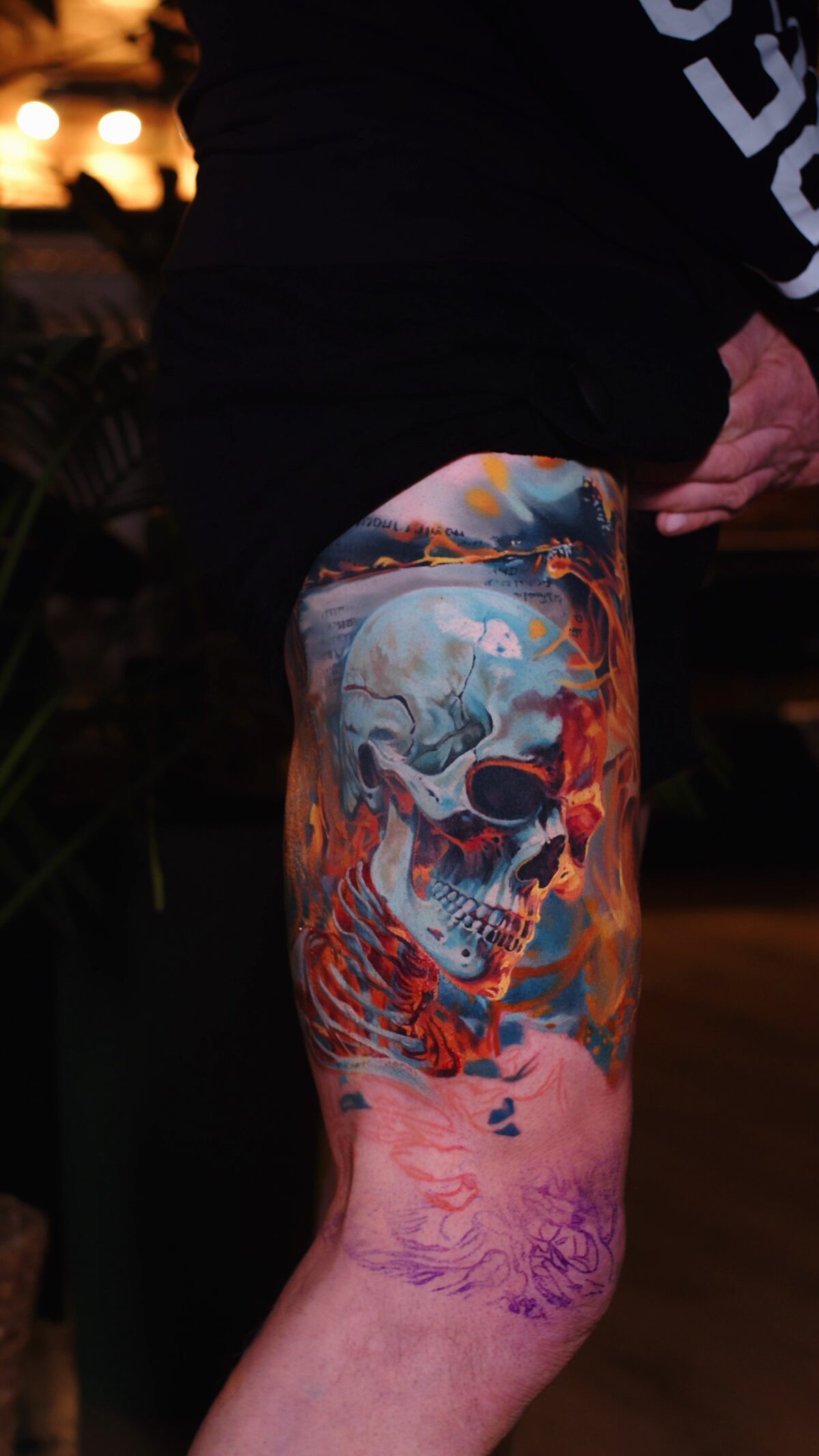 Kalt-Warm-Kontrast – das Blau des Schädelknochens gegen das Feuer, Hyperrealismus-Tattoo am Oberschenkel, Wrocław