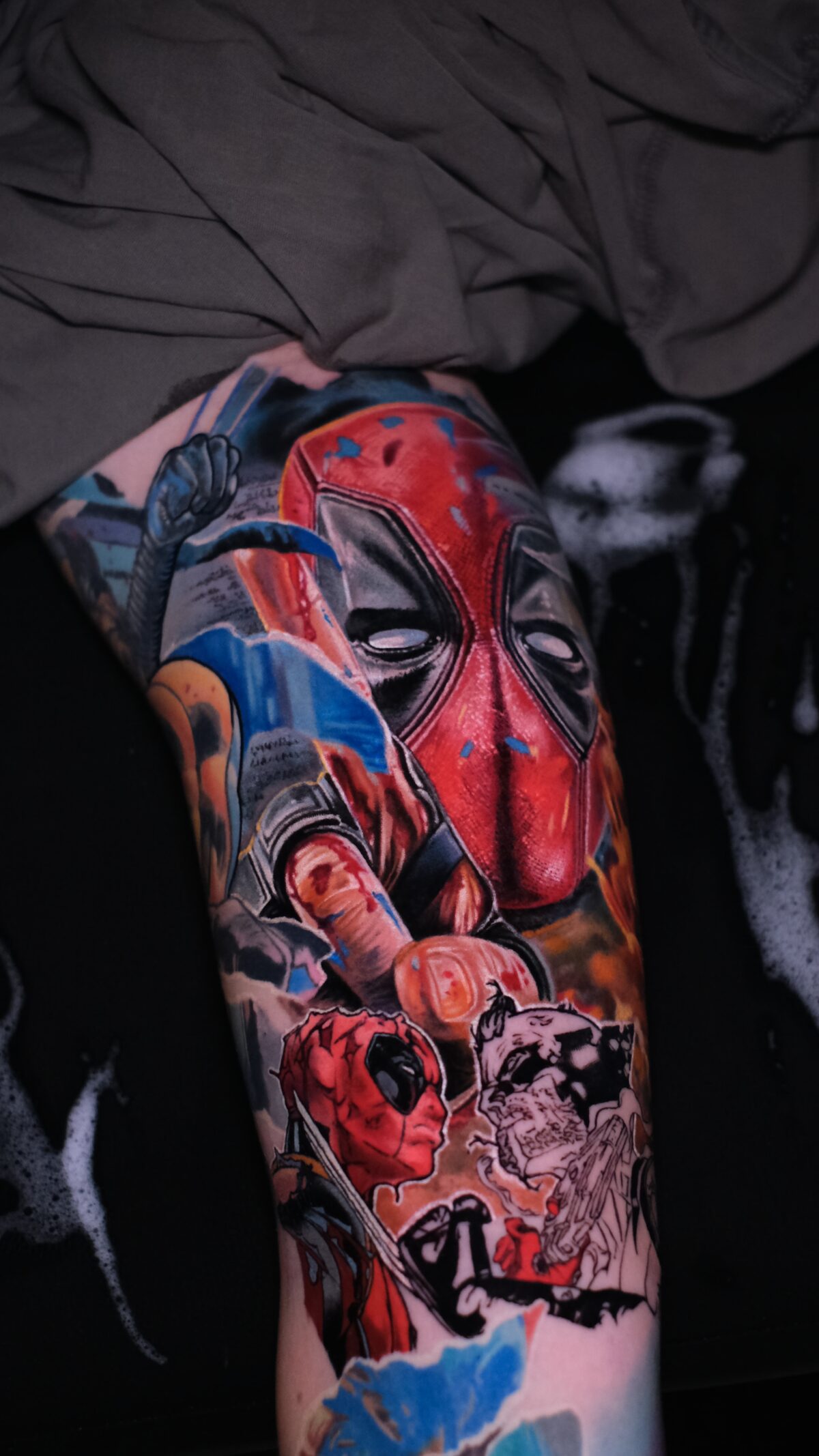 Gesamter Deadpool-Sleeve von oben: realistische Maske, Mittelfinger und darunter der Comic-Deadpool mit Katana, Tätowierer Wrocław.