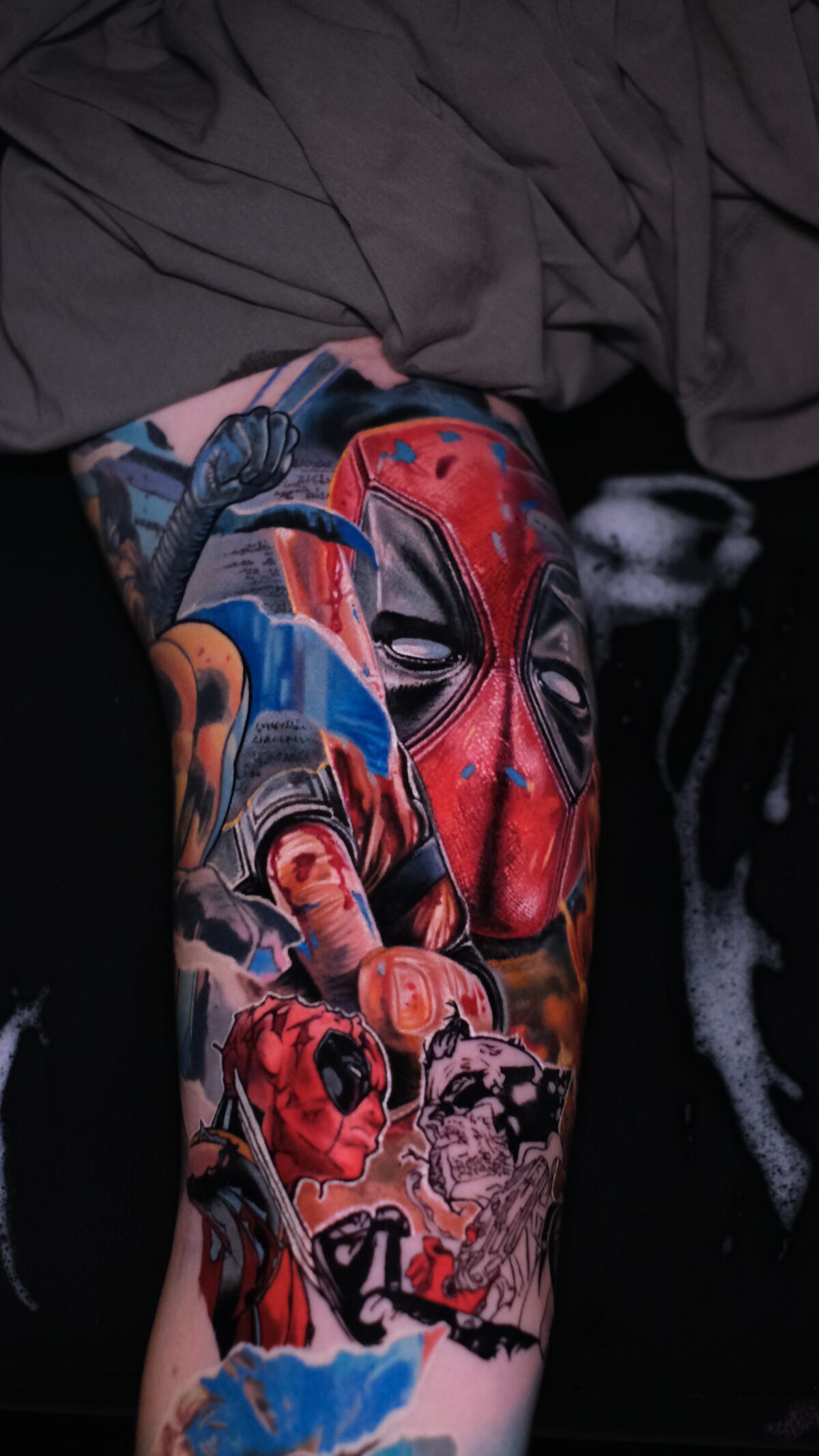 Deadpool-Maske mit den Comic-Panels und der blau-grauen Faust auf der linken Seite – Tattoo von Alex666cold, Breslau.