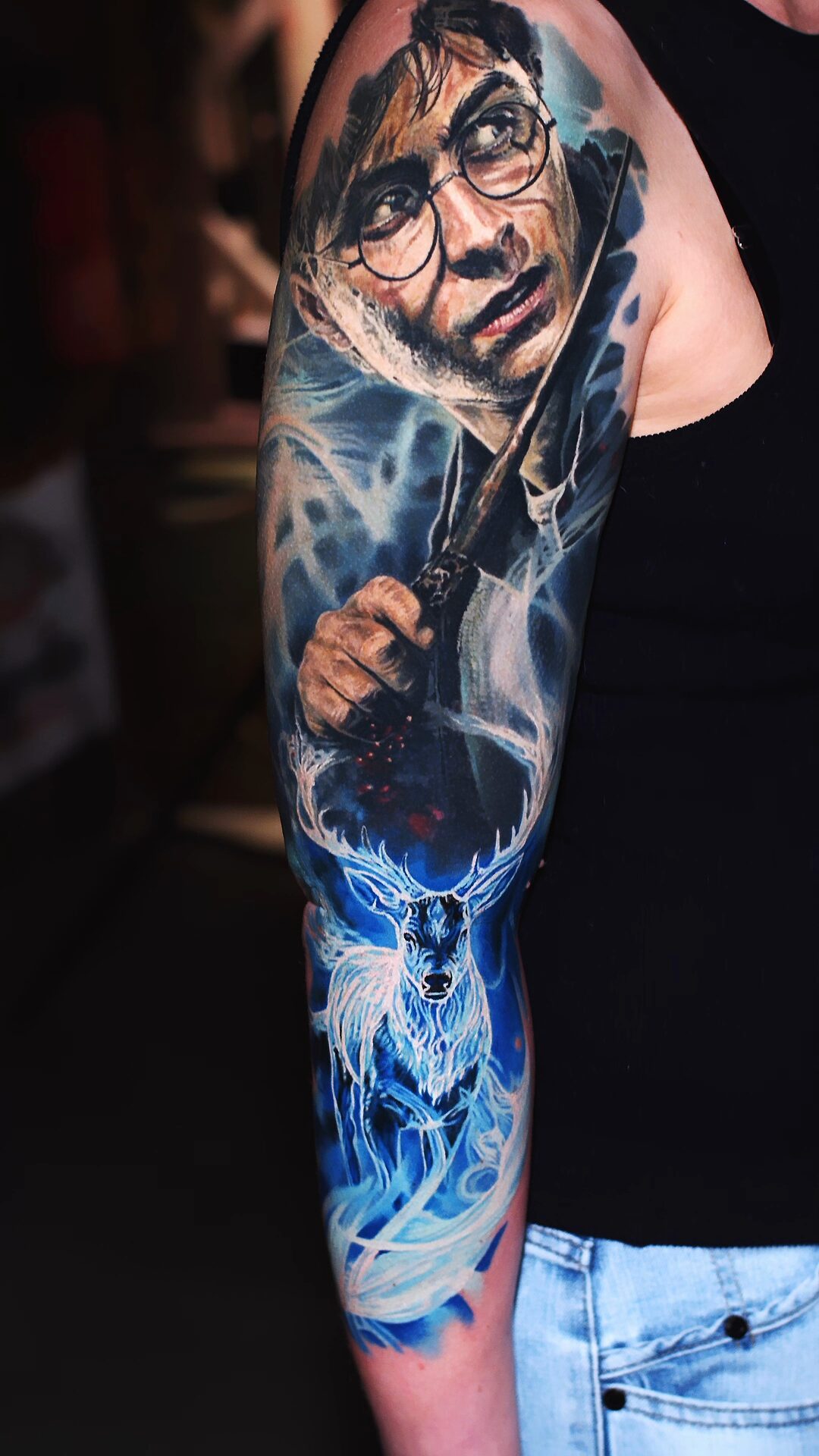 Hintergrund des Tattoos: filmisches, blaues Leuchten, stellenweise heller – realistisches Porträt-Tattoo, Wrocław