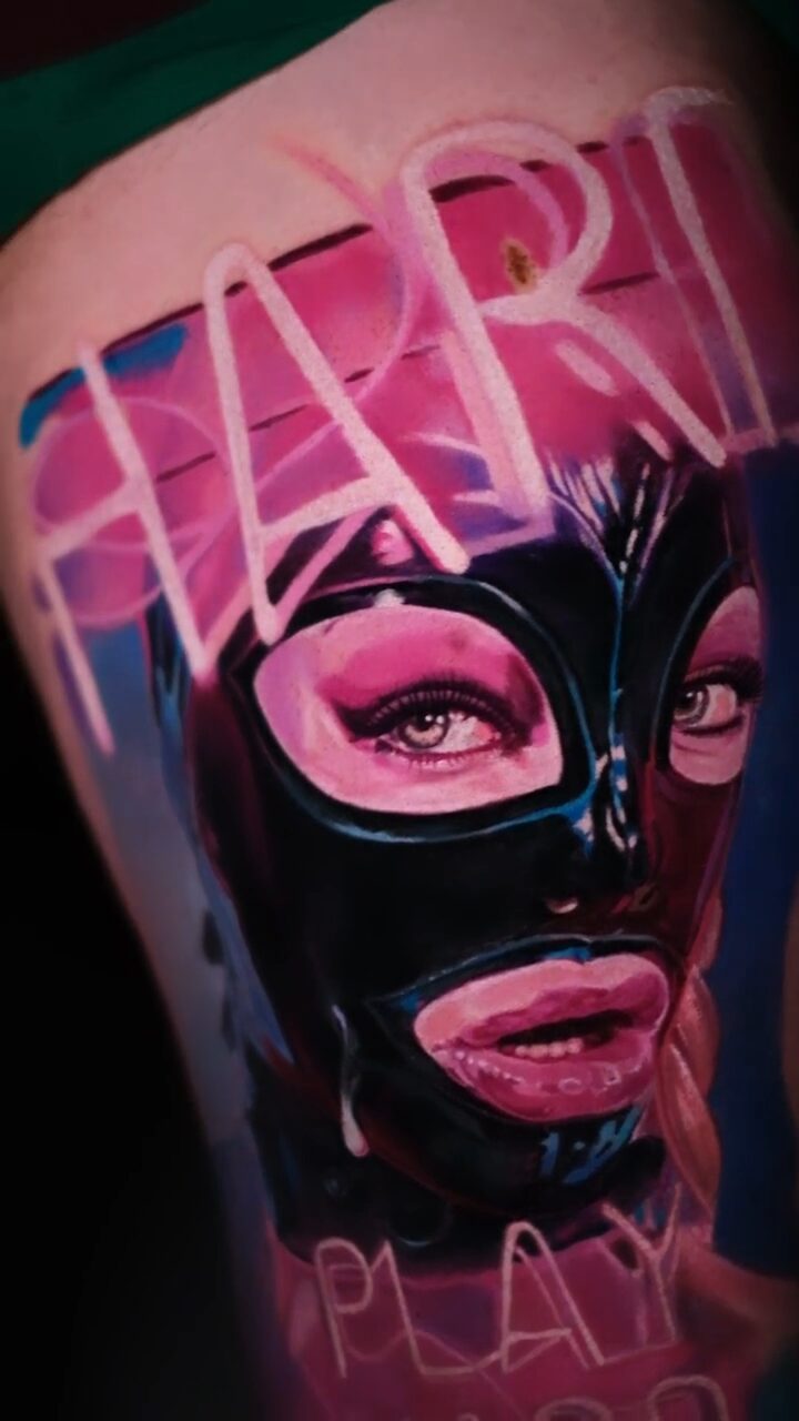 Gesamtkomposition – Frau in Maske und Schriftzug PLAY HARD, Tattoo am Oberschenkel, Wrocław
