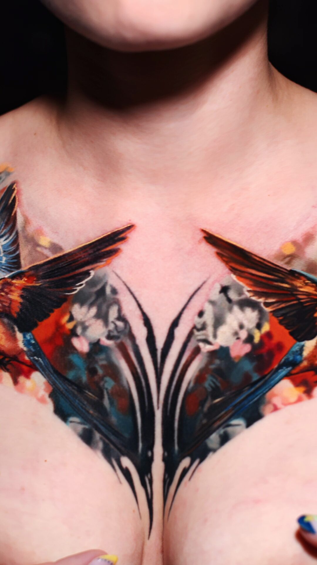 Detail der Blüten und grafischen Schwünge auf dem Brustbein – grafische Elemente im realistischen Tattoo