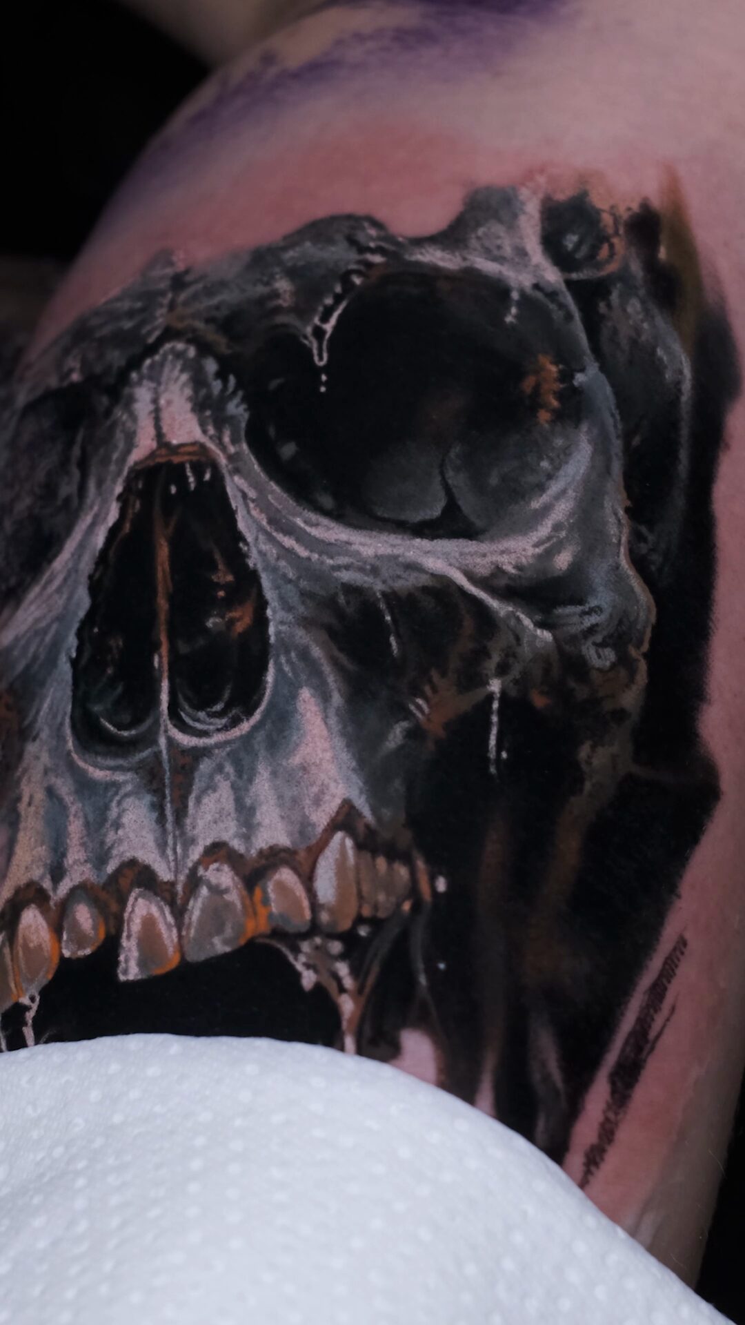 Seitenansicht des Tattoos – 3D-Tiefe und scharfe Kanten, realistischer Totenkopf am Oberarm in grey color