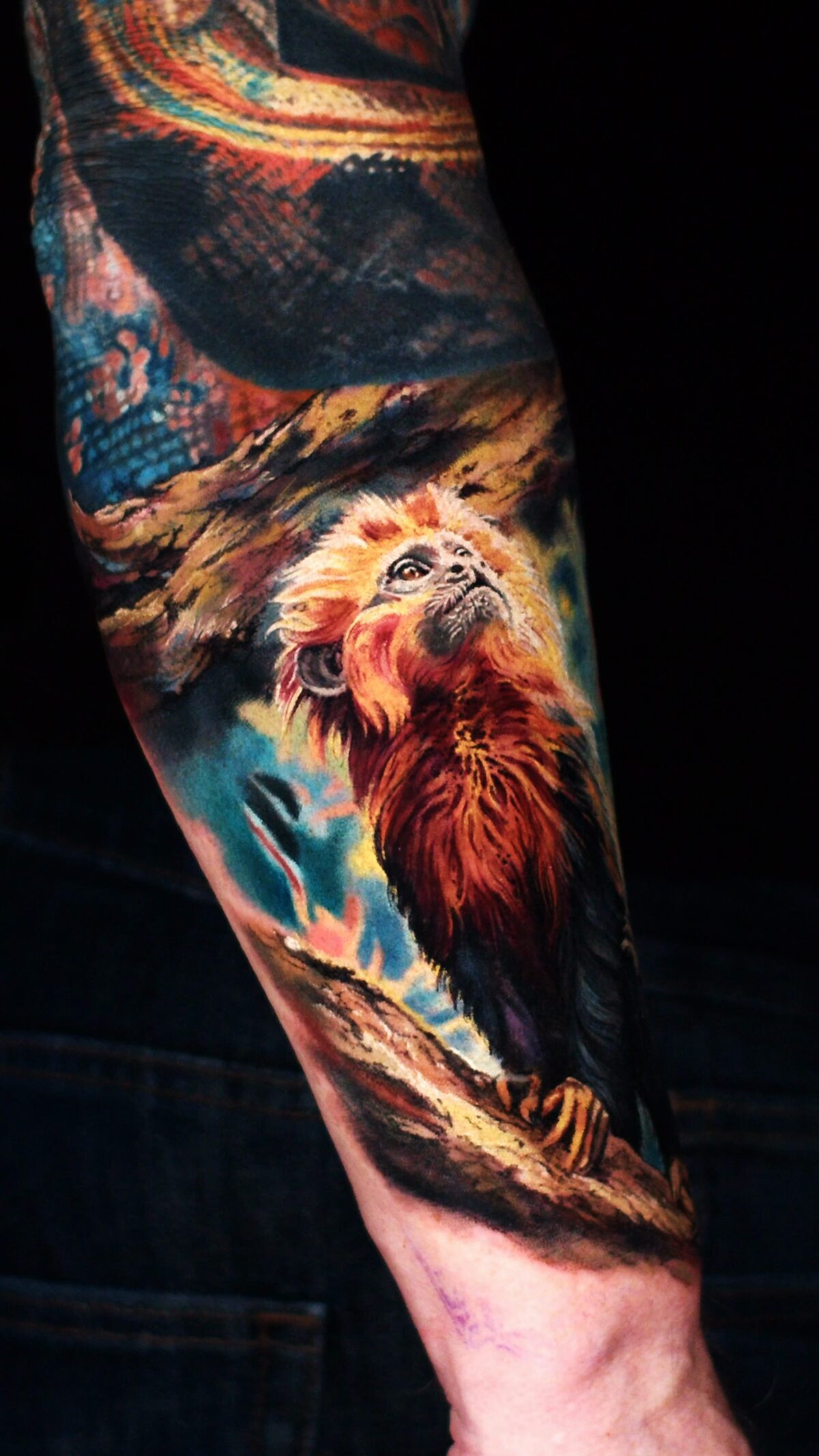 Türkisblauer Hintergrund im Affen-Tattoo – Kontrast zum Fell des Löwenäffchens.