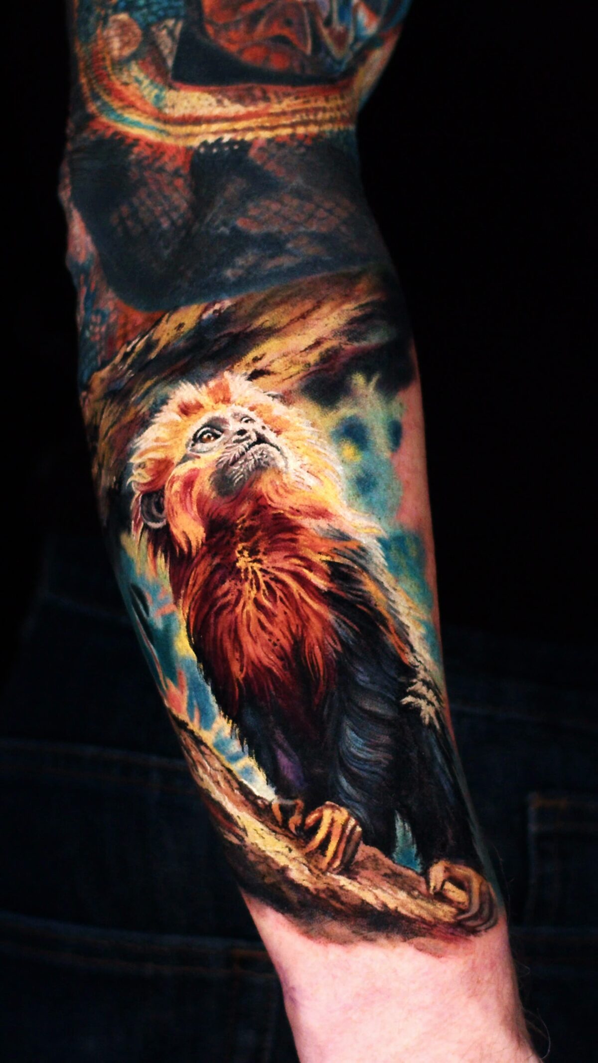 Goldenes Äffchen auf einem Ast – realistisches Tattoo auf dem Unterarm, Seitenansicht.